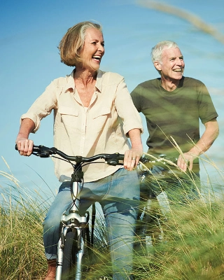 Ein aelteres Ehepaar in der Natur auf einer Radtour.